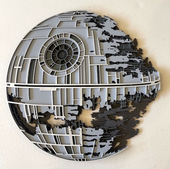 The Galactic Ruins: Death Star Wall Art Laser Cutting Project - This intricate wall art piece depicts the iconic Death Star, skillfully laser cut to capture the essence of its battle-worn, half-destroyed form. The multi-layered design brings out the detailed structure, with precise cuts showing the complex grid and internal details. Finished in grey and black, this piece beautifully illustrates the mechanical layers of the space station, making it a perfect addition to any sci-fi enthusiast’s decor, adding depth and a touch of the galaxy to any room.