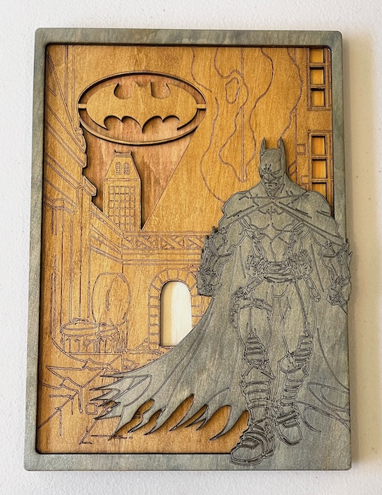 Dark Knight's Layered Legacy Laser Cutting Project - This laser-cut artwork features a stunning depiction of Batman standing heroically against a Gotham City backdrop. The iconic Bat Signal illuminates the sky, calling the Dark Knight to action. The intricate layering and engraved details bring the scene to life, showcasing the dark, moody atmosphere of the city. Perfect for superhero fans, this piece captures the essence of Gotham’s protector, combining artistry with a tribute to an enduring legend.