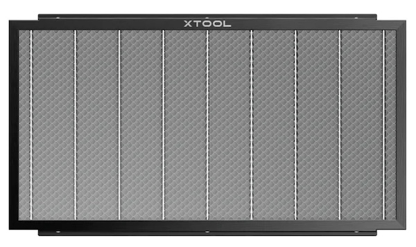 This image shows a rectangular honeycomb working panel by xTool, designed for laser cutting and engraving. The panel has a metal frame with a grid of small hexagonal cells, resembling a honeycomb pattern. This structure helps to support materials while allowing laser beams to pass through, reducing burn marks and improving airflow. It's ideal for projects requiring clean cuts and precise engraving, making it a valuable tool for laser craft enthusiasts.